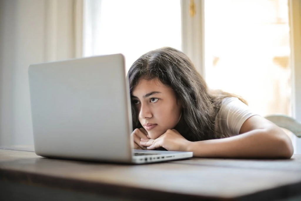 Девушка смотрит в экран ноутбука