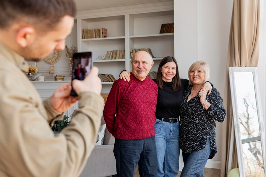 Мужчина фотографирует семью на телефон