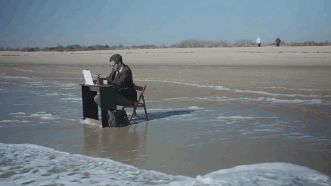 Мужчина за компьютером на пляже