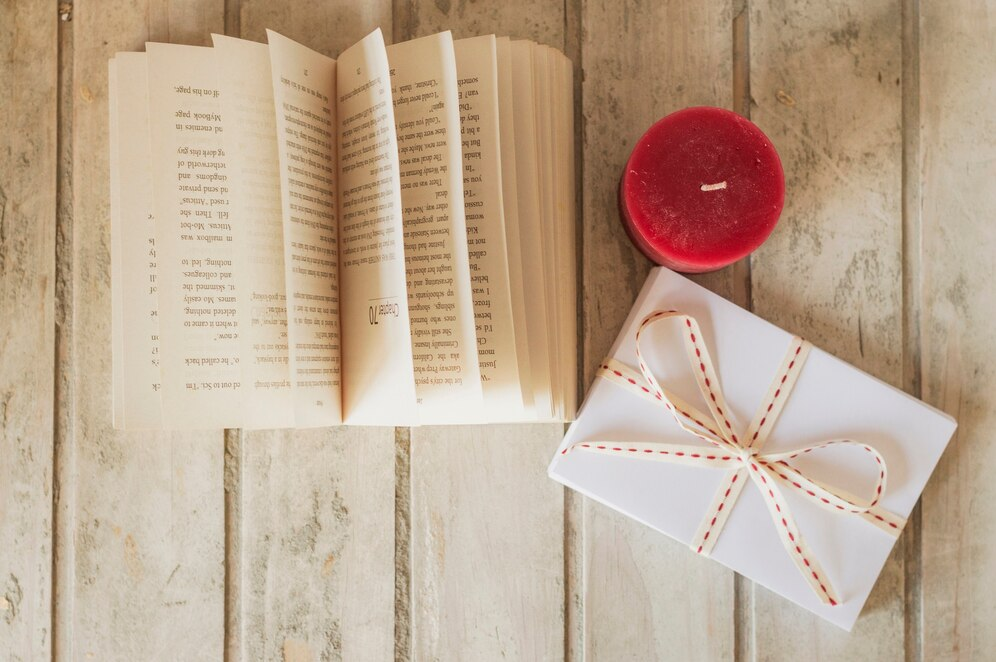 Книга, подарок и свеча на столе