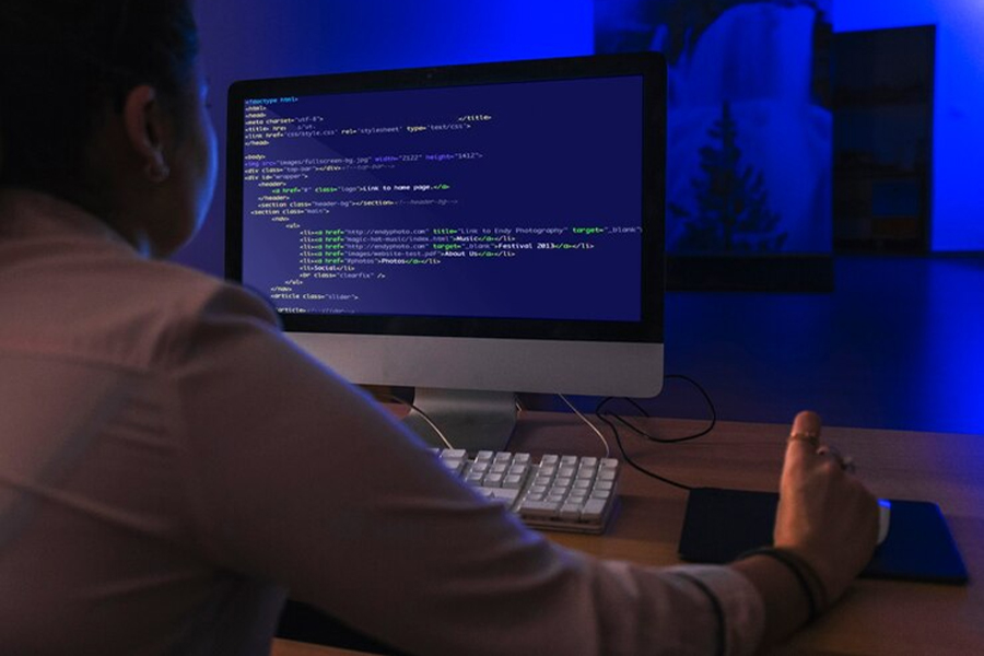 Программист проверяет код на компьютере